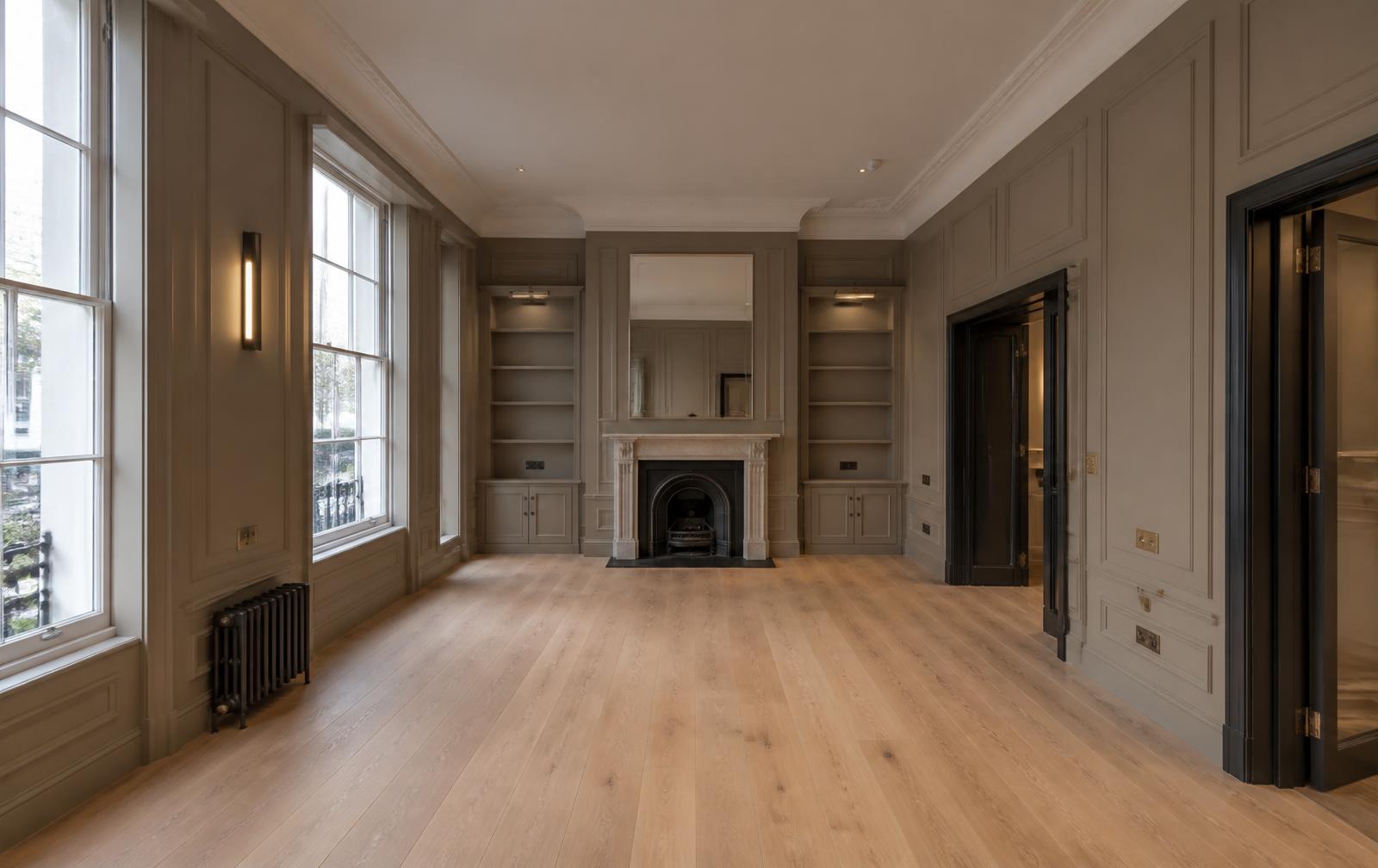 Fully refurbished London reception room with panelled walls, wide plank oak flooring and tall sash windows
